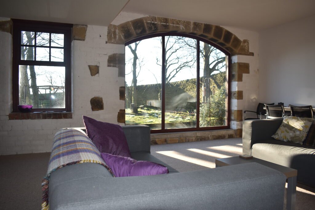 Comfortable seating beside the barn’s stone arched window