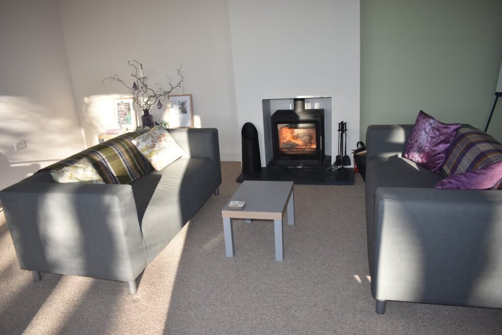 Sofas and a lit log burner inside Copster Barn